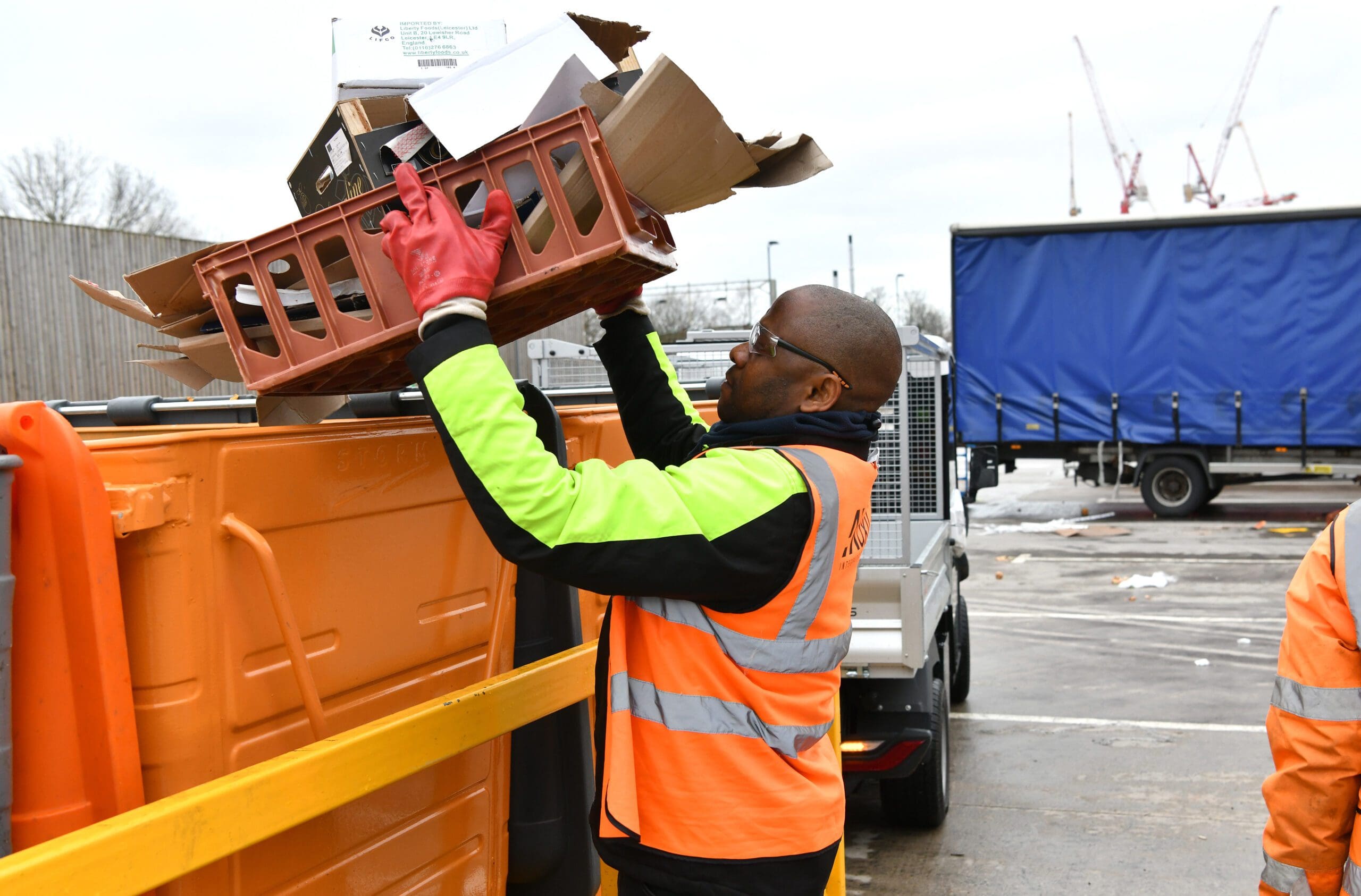 Axil employee putting cardboard into a recycling bin at Birmingham Wholesale Market