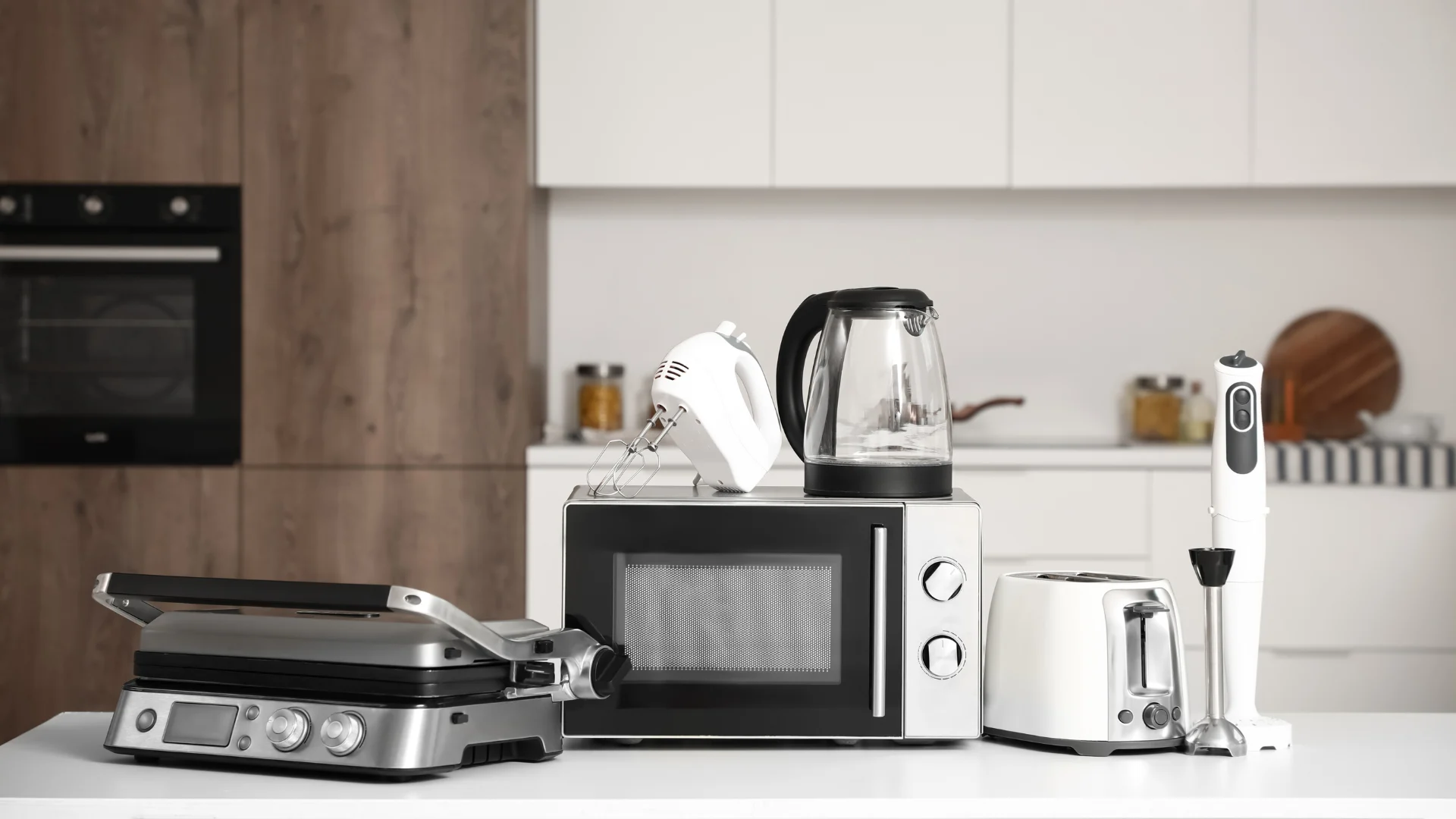 Different modern household appliances on table in kitchen